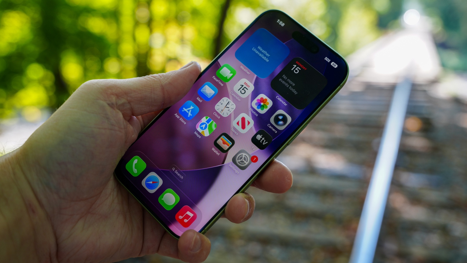 Hand holding a smartphone showing the home screen